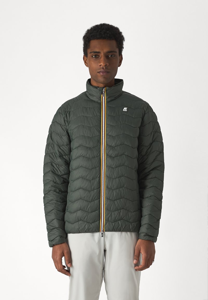 Green quilted jacket with a high collar, featuring a yellow zip and a small logo on the chest. Smooth fabric with a lightweight design.