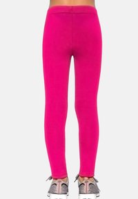 Legginsy w kolorze fuksji o gładkiej fakturze, z wysokim stanem i dopasowanym krojem, zestawione ze srebrnymi sneakersami z fakturowaną cholewką.