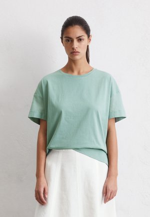 Light green cotton t-shirt with a crew neck and short sleeves, featuring a relaxed fit and a slightly longer back hem.