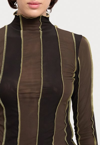 Haut en tulle noir et marron avec des accents de couture jaune ondulée et des détails de col volanté. Design ajusté.