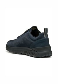 Zapatilla deportiva de un azul oscuro con un upper texturizado, que presenta detalles en negro, un collar acolchado y una suela de goma flexible y estampada.