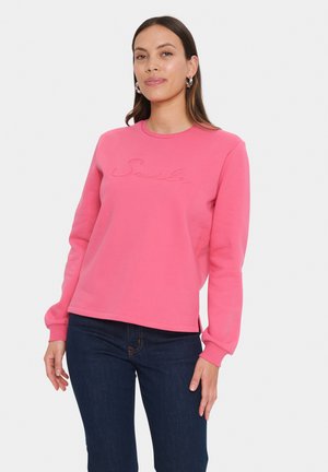 Felpa di cotone rosa con maniche lunghe, scollatura tonda e ricamo del logo "Smile" sulla parte frontale. Presenta una vestibilità comoda e spacco laterale.
