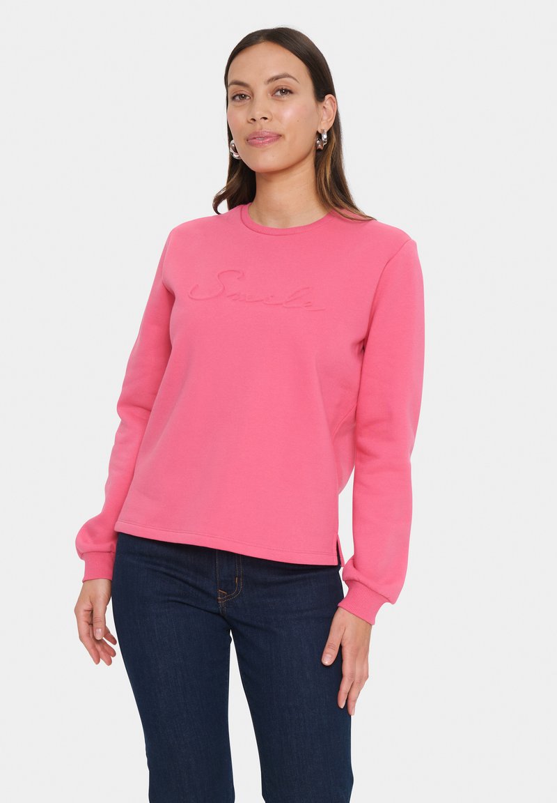 Felpa di cotone rosa con maniche lunghe, scollatura tonda e ricamo del logo "Smile" sulla parte frontale. Presenta una vestibilità comoda e spacco laterale.