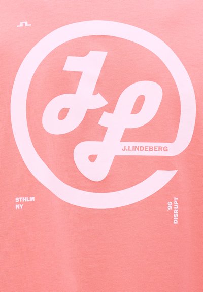 Ροζ ύφασμα με μεγάλο λευκό λογότυπο που συνδυάζει στυλιζαρισμένα γράμματα "J" και "L" σε κύκλο, κείμενο "J. Lindeberg," "STHLM NY," και "'96 DISRUPT."