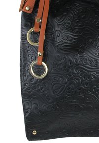 Zwarte lederen handtas met reliëf en golvende patronen, voorzien van hardware in goudkleur en een beige riem. De gestructureerde oppervlakte benadrukt het ontwerp.