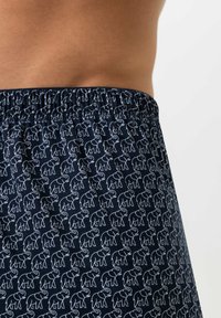 Marineblaue Badeshorts mit weißen Elefantenmustern, elastischem Bund, glattem Stoff und lockerem Schnitt.