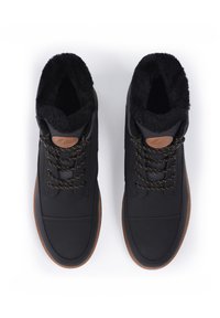 Schwarze High-Top-Schuhe aus weichem Material mit einem Kunstfellkragen, brauner Laufsohle und schwarzen sowie goldenen Schnürsenkeln mit einem strukturierten Akzent.