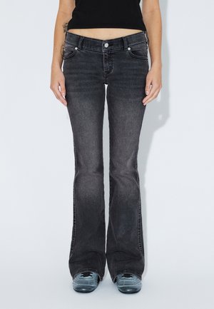 Black flared jeans with a high waist, featuring five pockets, a button closure, and a smooth denim texture. Waist is visible above.