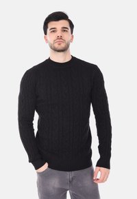 Maglione nero a maglia con colletto rotondo, polsini e orlo a costine; il tessuto appare testurizzato con un design accogliente e caldo.