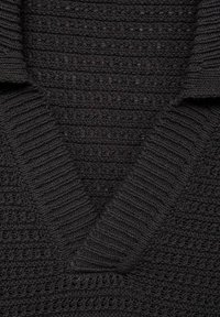 Maglione scuro lavorato a maglia con scollo a V, caratterizzato da costine testurizzate e una trama morbida e spessa. Il tessuto appare caldo e accogliente.
