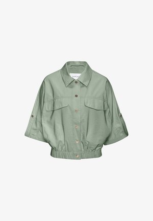 Light green cropped jacket with short sleeves, button front, two chest pockets, elastic waistband, and a collar.