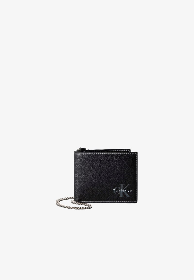 Portefeuille Calvin Klein en cuir noir texturé avec coutures blanches et chaîne argentée attachée sur fond blanc.
