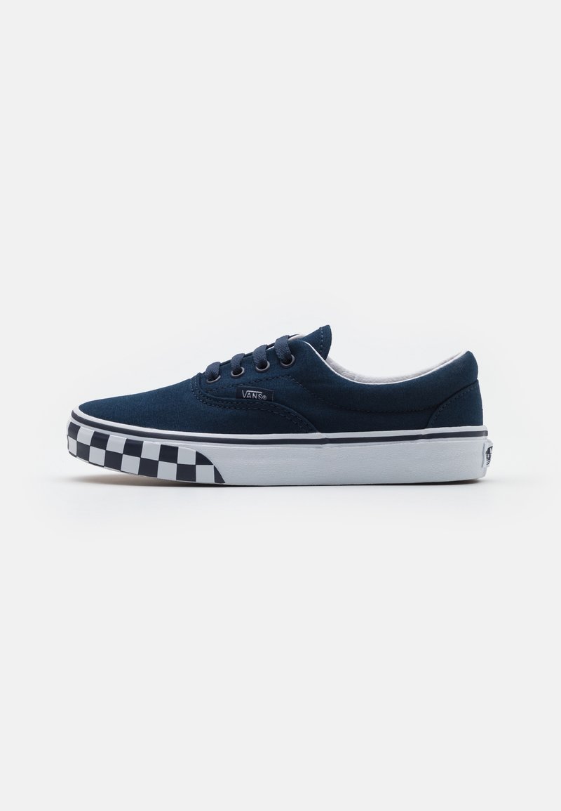 Baskets basses Vans bleu marine avec motif damier noir et blanc sur la semelle et semelle intermédiaire blanche.