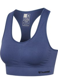 Niebieski bezszwowy biustonosz sportowy z designem racerback, oddychająca tkanina, logo Hummel na dolnej opasce i widoczna metka pielęgnacyjna wewnątrz tyłu.