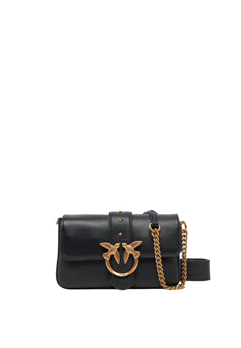 Sac à épaule en cuir noir avec une forme incurvée et un accent en métal doré en forme d'oiseau. Dispose d'une chaîne pour la bandoulière et d'une fermeture à boucle cloutée. Texture lisse.