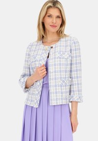 Tweedowa kurtka w pastelowym niebieskim i białym kolorze z teksturowanym wzorem, skrócony fason, cztery kieszenie i kwiatowe guziki, zestawiona z lawendową sukienką.