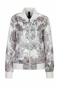 Vit bomberjacka med blommiga och lejongrafiker i pastellfärger. Har dragkedja framtill, ribbade ärmslut och hög krage.