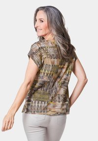 Meerkleurig kortmouwtop in aardetinten van geel, bruin en zwart. Lichtgewicht stof met een losse pasvorm en een ronde zoom.