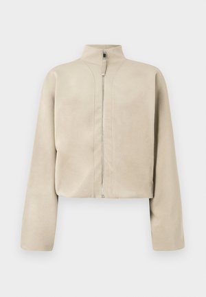 Cropped, beige zip-up jacket with high collar and long sleeves. Made from smooth fabric with subtle sheen and minimal stitching details.