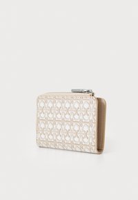 Portefeuille beige avec un motif gaufré, fermeture éclair en argent, et texture lisse d'un côté, avec un dos en cuir beige contrastant.