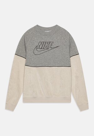 Sweat-shirt Nike gris et crème avec une finition texturée, présentant un logo noir proéminent, des manches raglan et un ourlet côtelé.