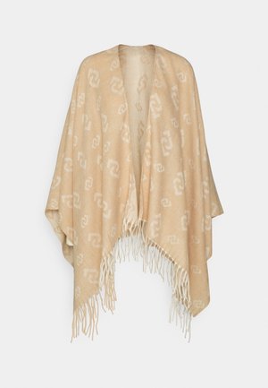 Châle beige avec motif chaîne blanche entrelacée, ouverture devant et bords à franges, présenté sur un fond clair uni.
