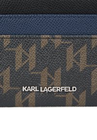 Fekete, texturált pénztárca barna és arany mintázattal, a „Karl Lagerfeld” ezüst logóval feltűnően elhelyezve.