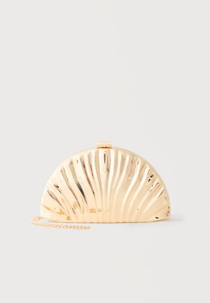 Pochette demi-cercle en métal doré avec des rainures rayonnantes et une chaîne fine, posée sur un fond gris clair uni.