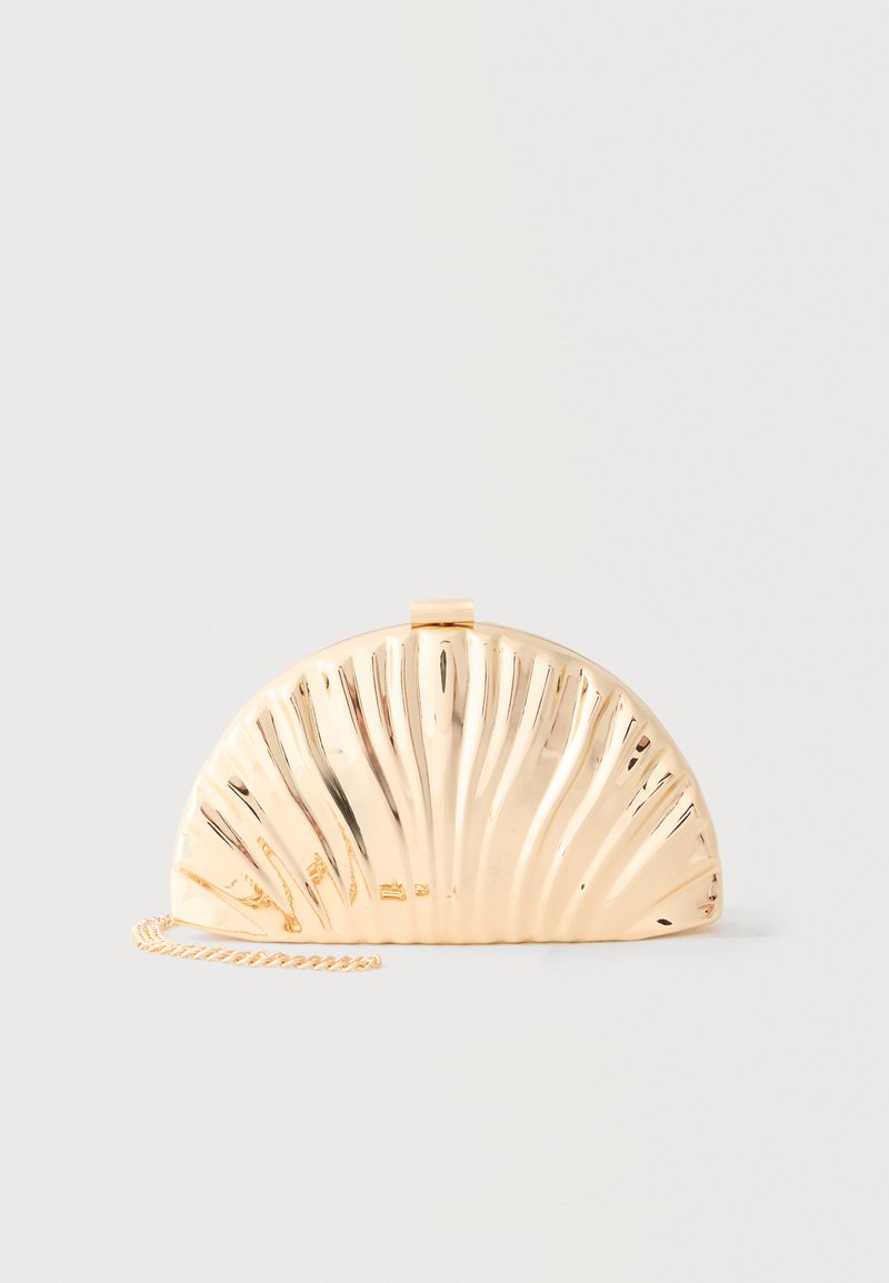 Χρυσό μεταλλικό τσαντάκι φάκελος σε ημικυκλικό σχήμα με ακτινωτές ραβδώσεις και λεπτή αλυσίδα, τοποθετημένο πάνω σε απλό γκρι ανοιχτό φόντο.