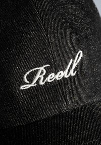 Black denim cap featuring white embroidered "Reoll" logo, textured fabric with visible stitching, and a curved brim.
