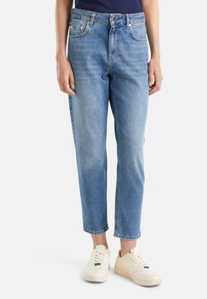 Jeans en denim bleu clair à taille haute, jambe droite et décoloration subtile. Comprend des poches avant et arrière, des boutons en laiton et des surpiqûres doubles.
