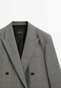 Blazer gris croisé avec revers crantés, boutons noirs et étiquette intérieure noire portant la mention "Massimo Dutti Made in Portugal."