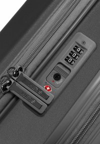 Grauer Koffer mit doppelten Reißverschlüssen und "HEYS"-Logo, einem Kombinationsschloss und einer strukturierten Oberfläche für Langlebigkeit.