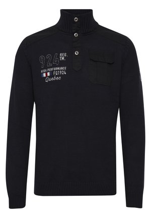 Marineblå strikkegenser med høy krage, tre knapper, skulderdetaljer og en frontlomme; har broderte tekster og mønstre.