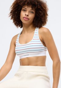 Σπορ σουτιέν Calvin Klein, ανοιχτό μπλε με οριζόντιες κόκκινες και ναυτικές ρίγες, λευκή ελαστική ζώνη με λογότυπο, μαλακή ραβδωτή υφή.