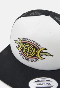 Gorra snapback con una parte frontal blanca y trasera de malla negra, que presenta un diseño gráfico de serpientes y símbolos circulares en amarillo, rosa y negro.