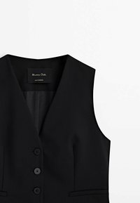 Veste noire sans manches, cintrée, avec col cranté et trois boutons à l'avant sur fond blanc.