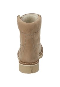 Stivaletto alla caviglia in suede beige con punta rotonda, fodera morbida, suola robusta beige e dettagli cuciti sul tallone e sulla gamba.