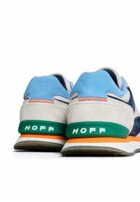 Baskets en daim bleu, gris et marine avec des accents verts et orange, présentant un talon texturé et un logo "HOFF" audacieux à l'arrière.