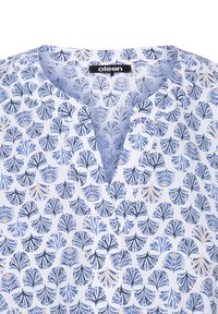 White blouse featuring a blue and gold leafy pattern, v-neckline, soft fabric, and a tag labeled "olsen."