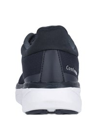 Musta urheilujalkine, jossa on verkkomateriaali ylhäällä, pehmustettu nilkka ja valkoinen kumipohja. Ominaisuuksiin kuuluu sileä kantapääosa ja brändäys takana.