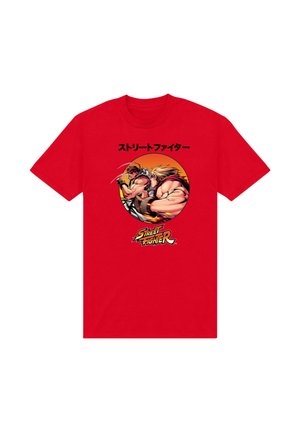 T-shirt rouge avec deux personnages musclés de Street Fighter en position de combat, texte japonais au-dessus et logo Street Fighter en dessous.