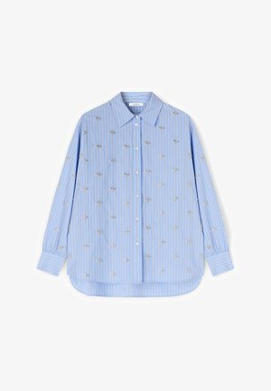 Jasnoniebieska koszula z długim rękawem zapinana na guziki, z pionowymi białymi i brzoskwiniowymi paskami oraz małym srebrnym haftem w kształcie gwiazdek na całej tkaninie.