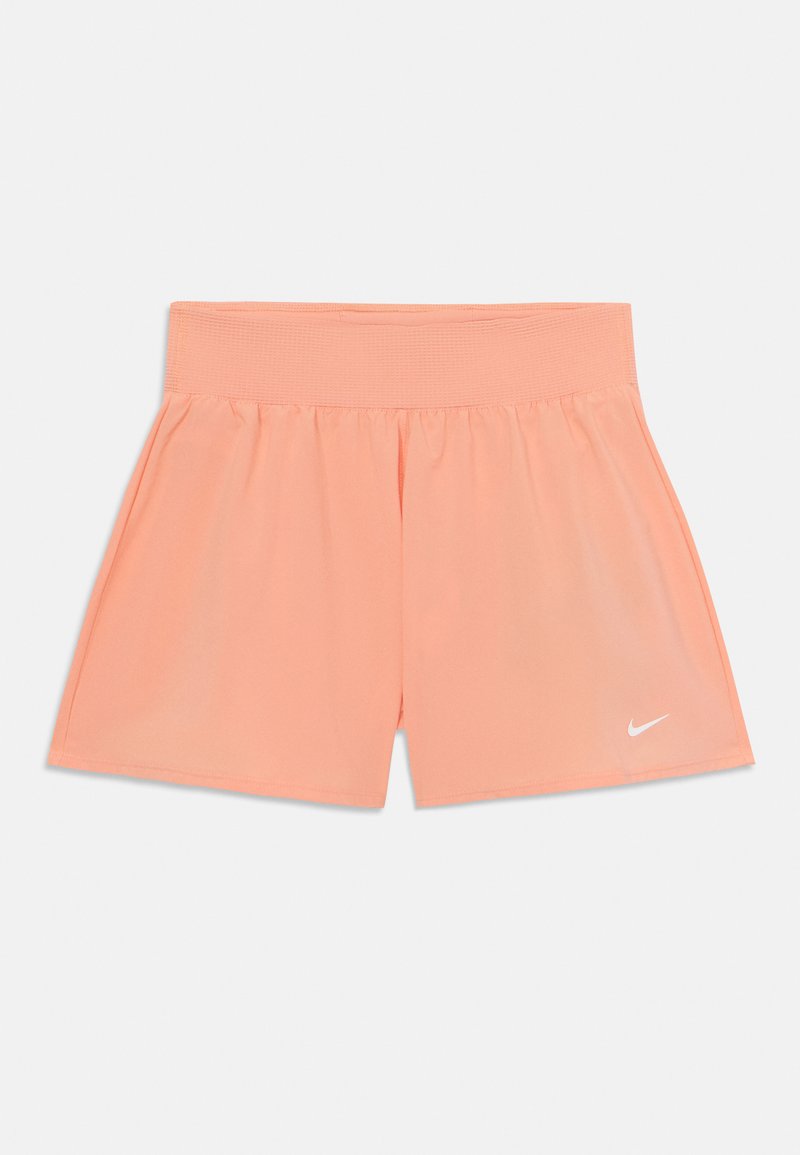 Lätta persikofärgade träningsshorts med en bred elastisk midja och en liten vit Nike-logotyp på nedre vänstra framsidan.