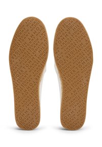 Semelles de chaussures en caoutchouc brun avec une texture à motifs comportant le nom "Tommy Hilfiger" répété partout. Bords blancs sur les côtés.