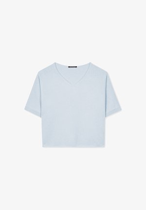 Short-sleeve, light blue crop top made from soft fabric, featuring a V-neckline and relaxed fit with a smooth texture and no embellishments.