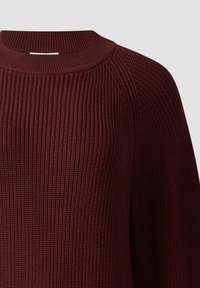 Burgundowa sweter z dzianiny o prążkowanej strukturze, szerokim dekolcie i rękawach raglanowych. Materiał wydaje się miękki i ciepły.