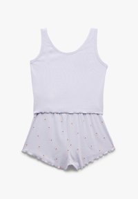 Débardeur violet au tissu lisse et aux bords festonnés, porté avec un short à motif floral rose sur fond lavande.