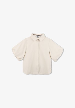 Blusa de manga corta de color crema con cuello puntiagudo y botones ocultos, con un corte holgado y una pequeña etiqueta dorada con el logo en el dobladillo.