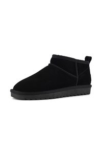 Botas de tobillo de ante negro con punta redondeada, costuras mínimas y suela de goma texturizada. Cuenta con una pestaña en la parte posterior para facilitar su puesta.